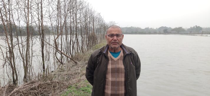 Man standing near a flooded field
