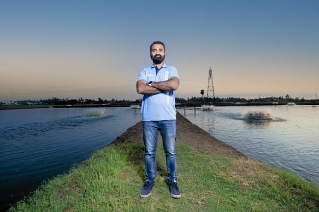 a man standing beside a fish farm