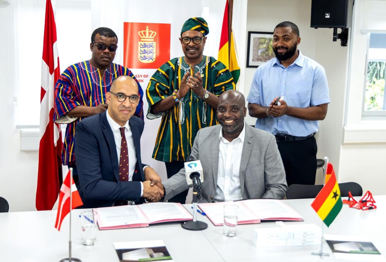 Five men shaking their hands after signing an agreement in Ghana.