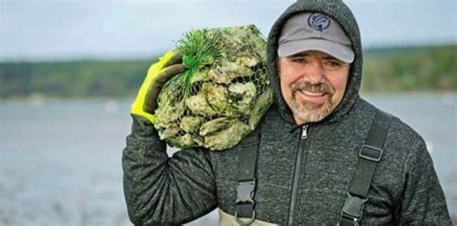 a man carrying a bag of oysters