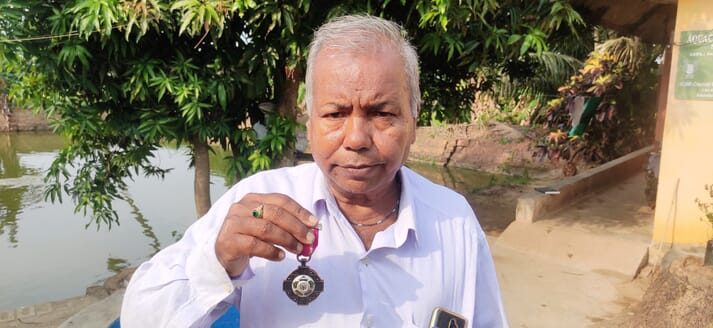 man holding Padma Shri medal