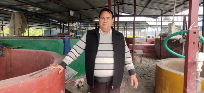 Man standing next to concrete tanks