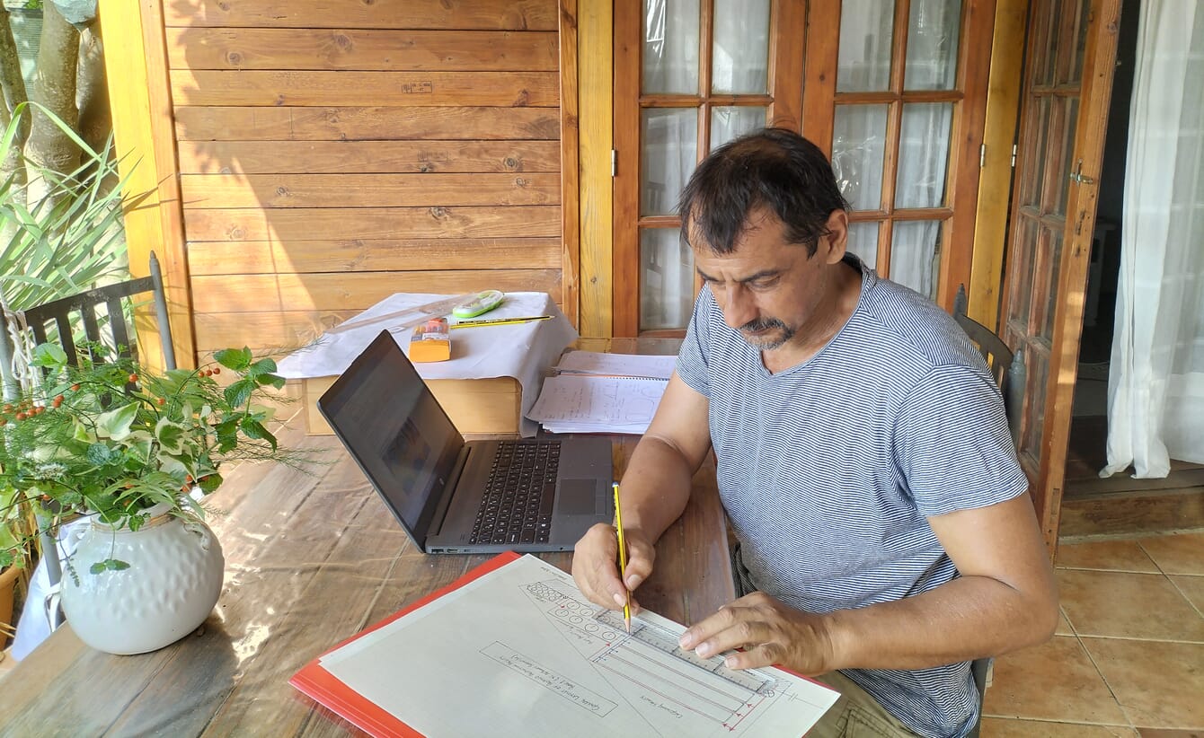 Man working on a technical drawing at a desk