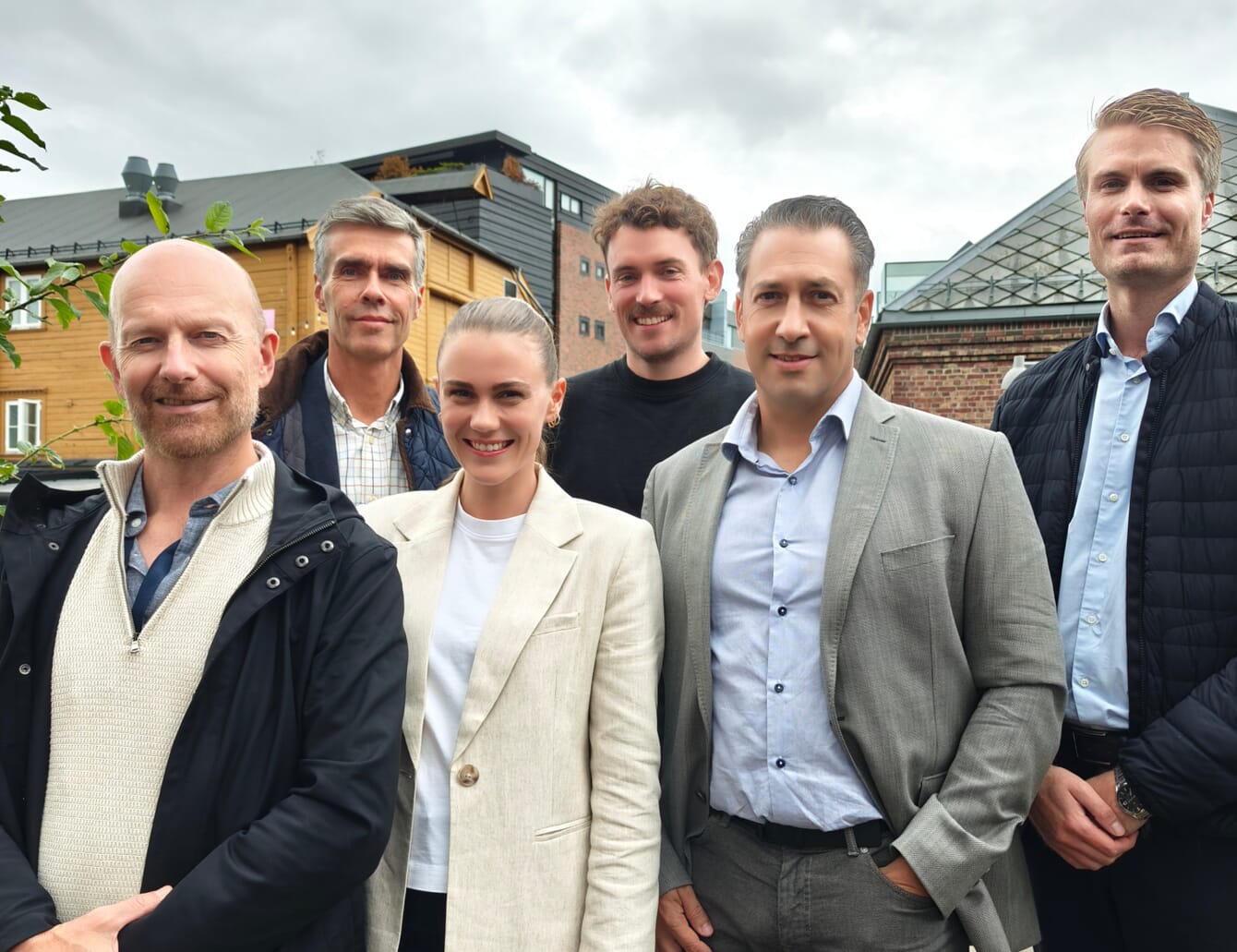 A group of six people celebrating an investment.