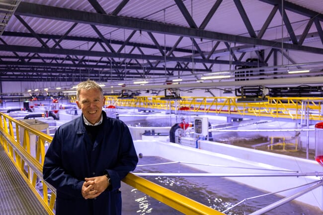 A man standing in a fish farming unit.