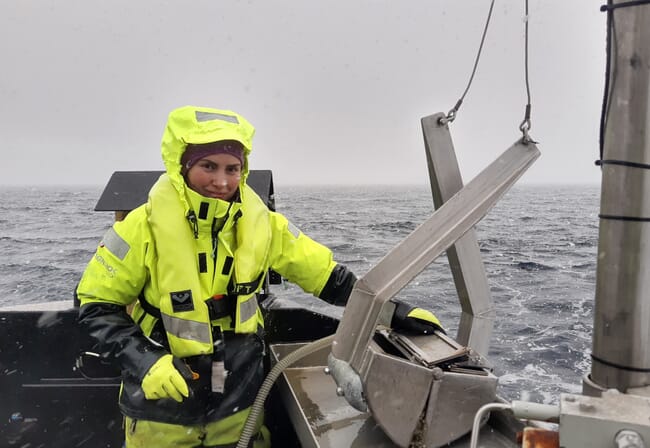 A scientist sampling sediment