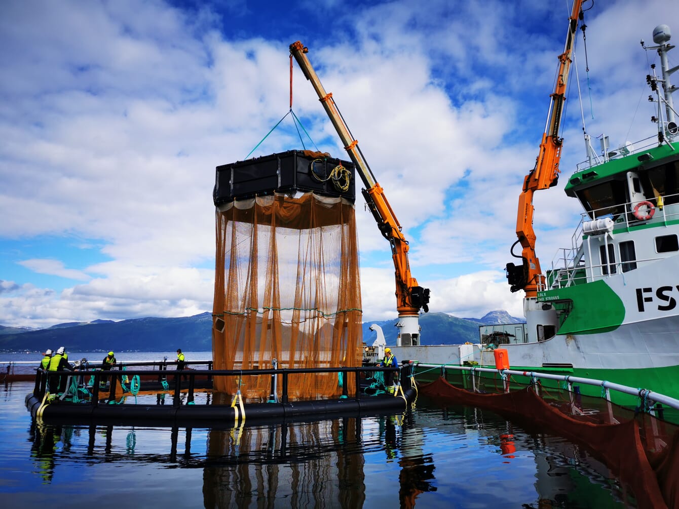 salmon pen being lifted out of the water