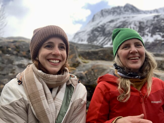 two women in front of some snowy hills