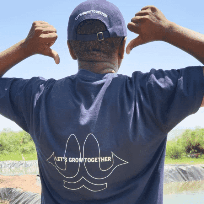 A man pointing to the slogan on his t-shirt