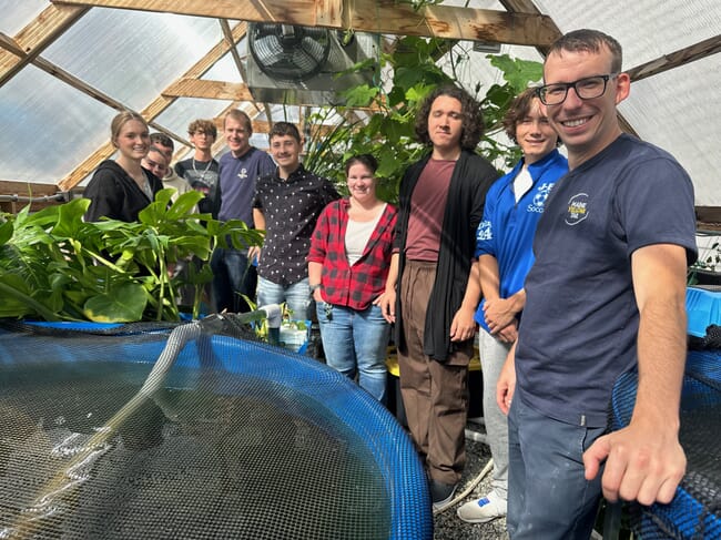 people standing around a fish tank