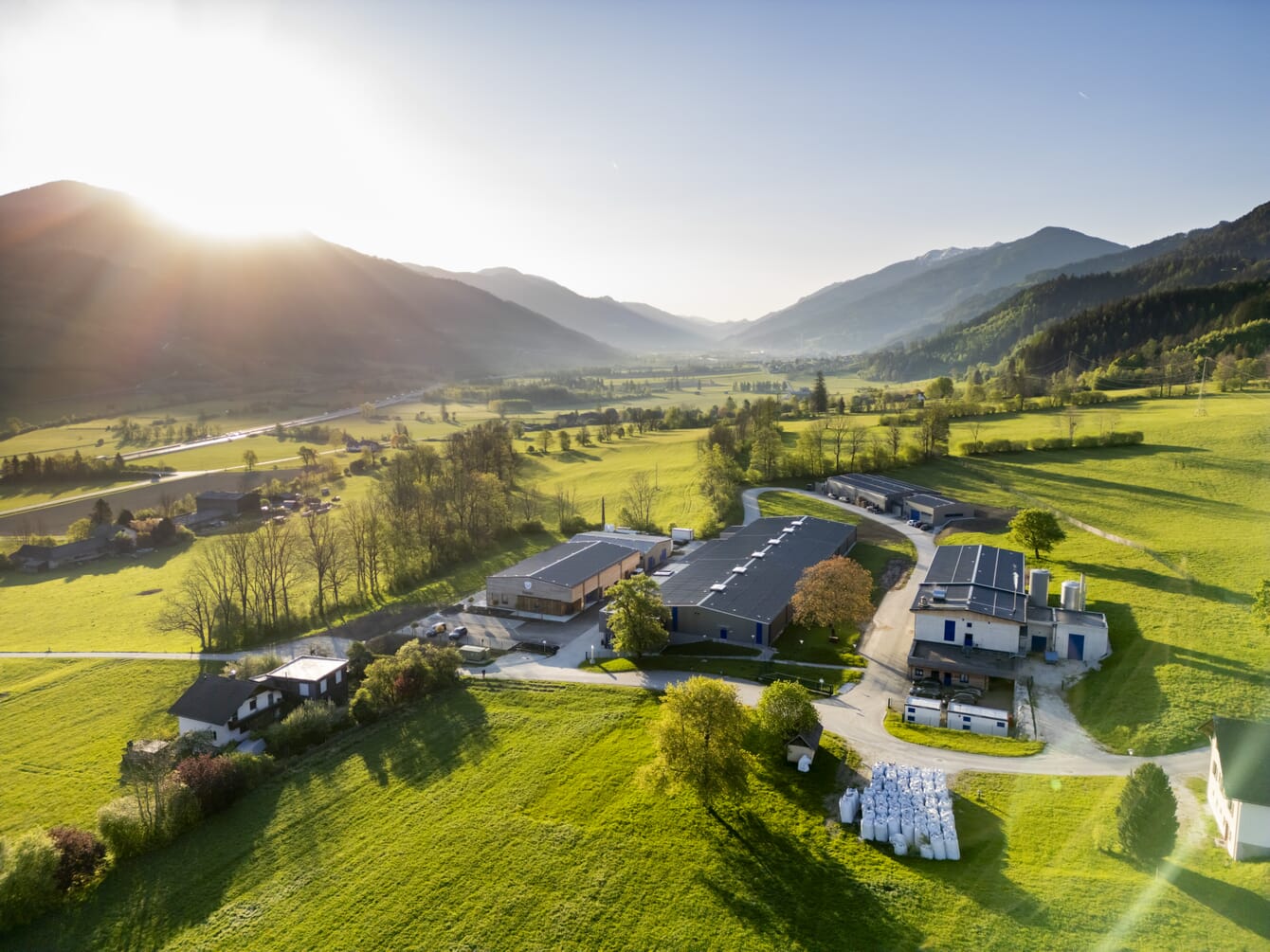 Vista aérea de una piscifactoría de camarones en un valle verde.