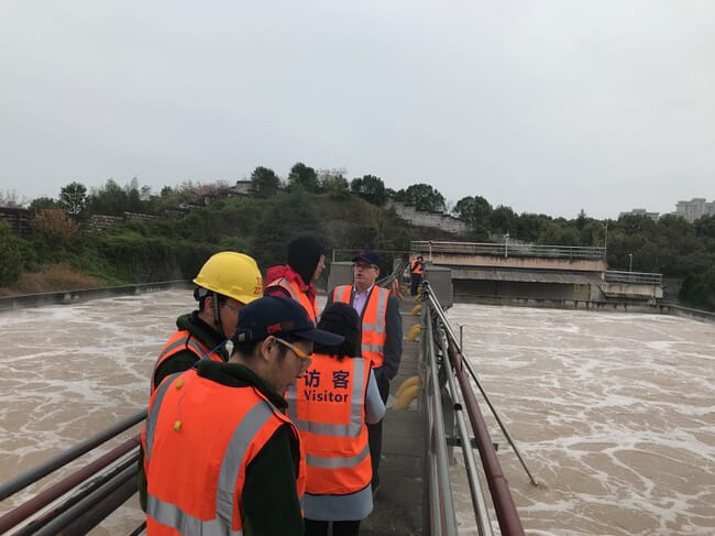 groups standing over a wastewater reservoir