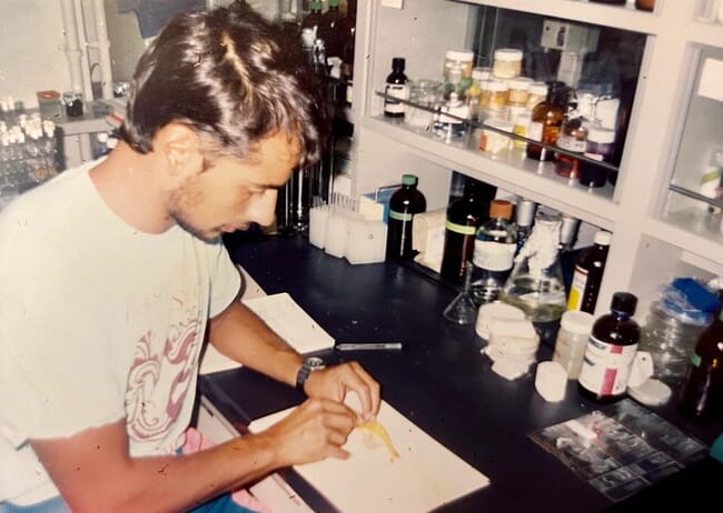 um homem inspecionando um camarão em um laboratório