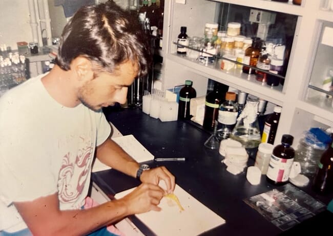 a man inspecting a shrimp in a laboratory