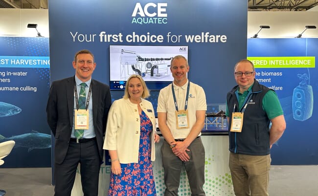Four people standing at a trade show.