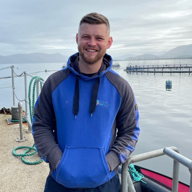 A man standing in front of a fish farm.