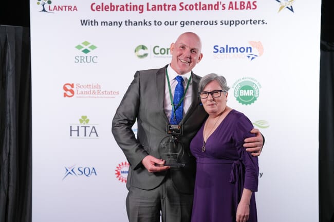 Two people on stage at an awards ceremony.