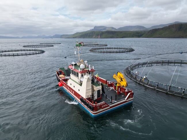 A boat beside some fish pens.