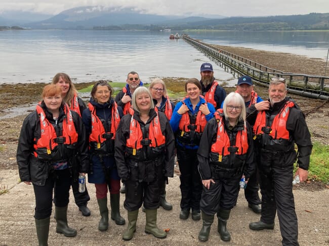 A group of politicians visiting a salmon farm.