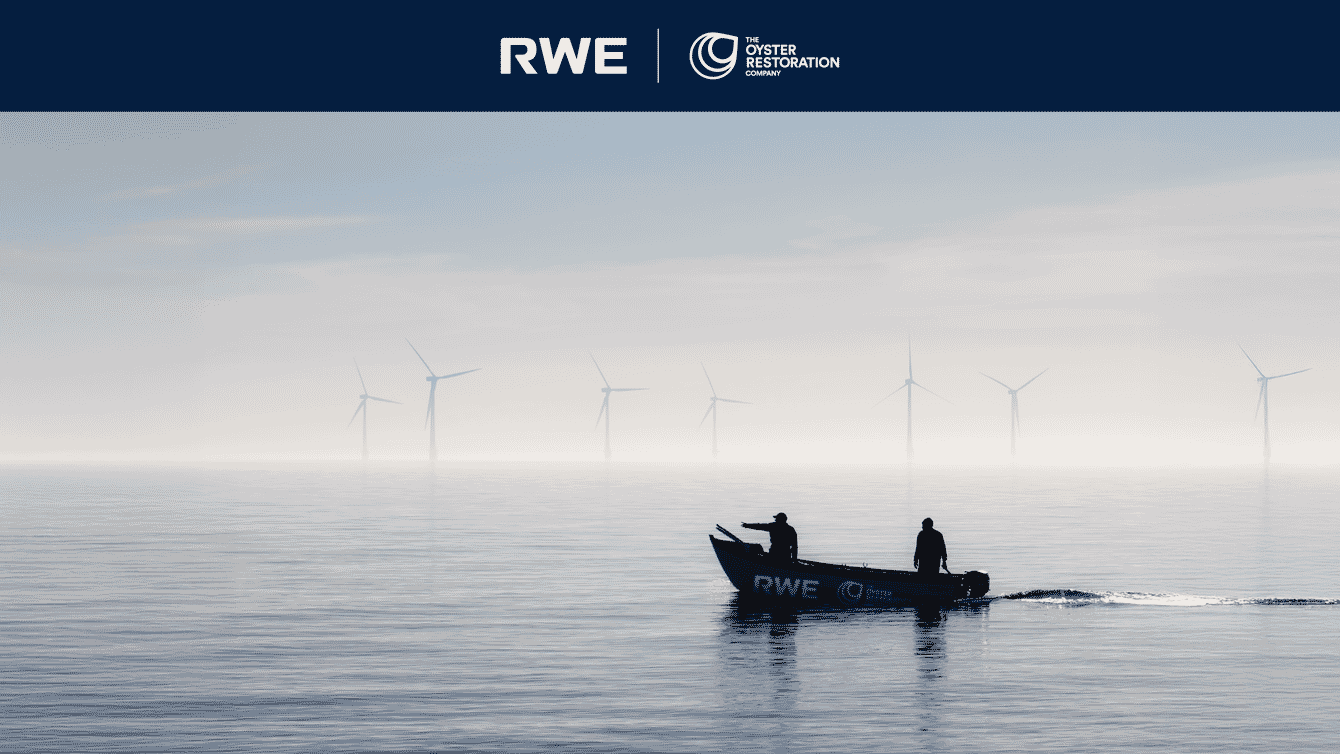 A boat infront of a windfarm.