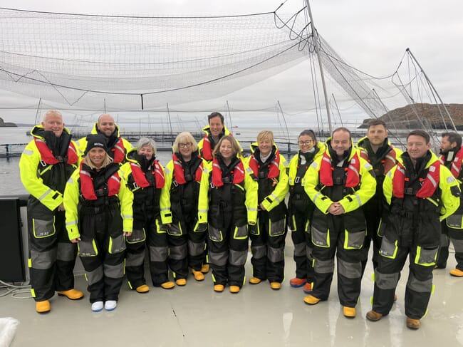 A group photo beside a fish pen.