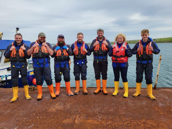 people in lifejackets posing for a photo