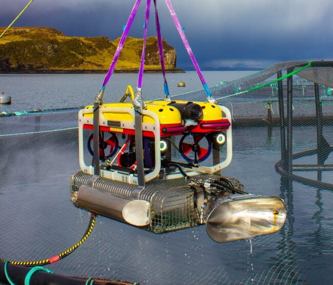 Un ROV colgando sobre un corral de salmones.