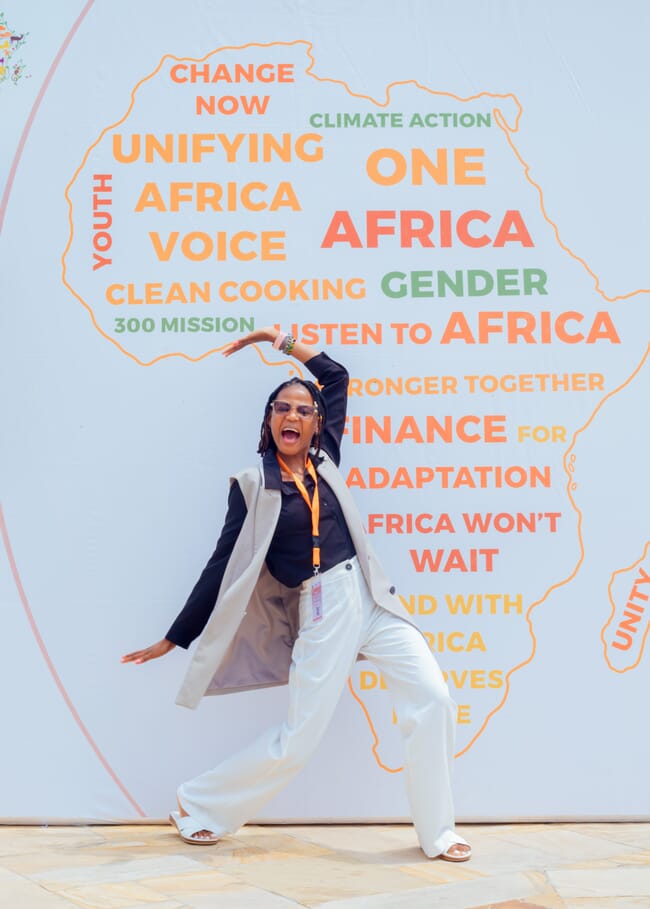 A woman striking a pose in front of a map of Africa.