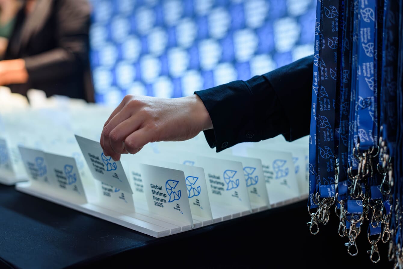A person taking registration cards during a shrimp forum.