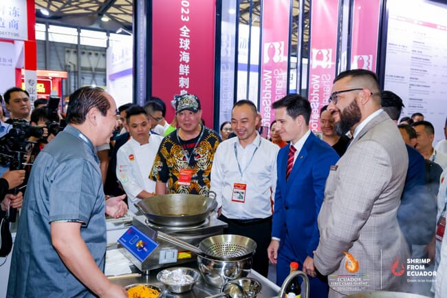 A group of men are shown how to cook Ecuadorian shrimp