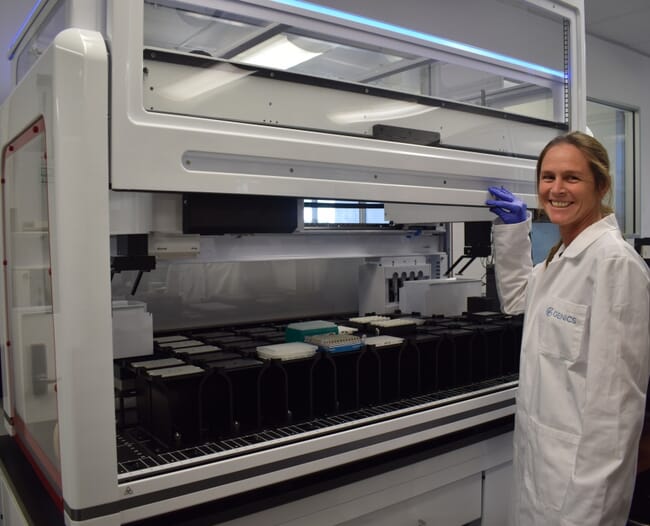 Mulher sorridente em pé em um laboratório de pesquisa