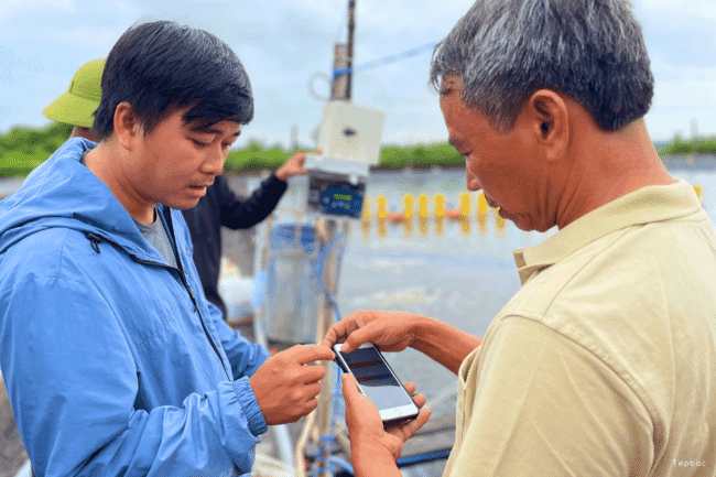 Two men looking at a mobile phone