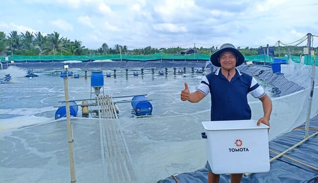 Shrimp farmer by pond