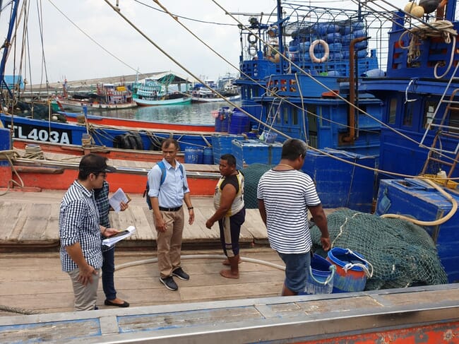 people examining a fishing vessel