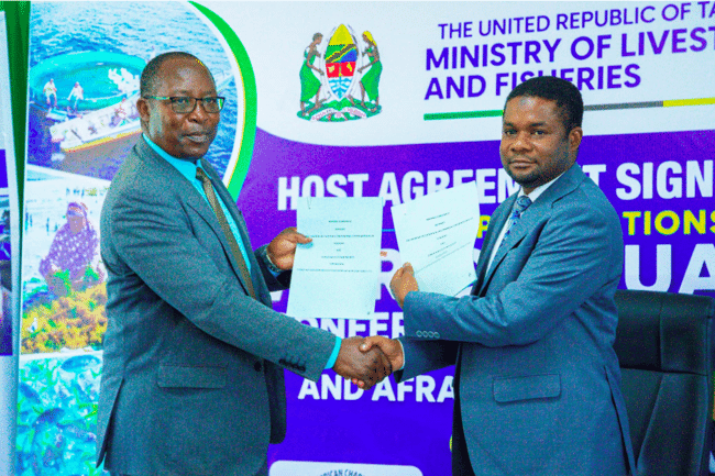 Two men sharking their hands after signing an agreement.