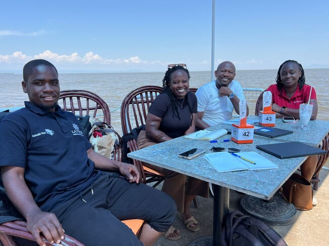 Four people sitting around an outdoor table.