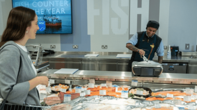 A customer being served at a fish counter.