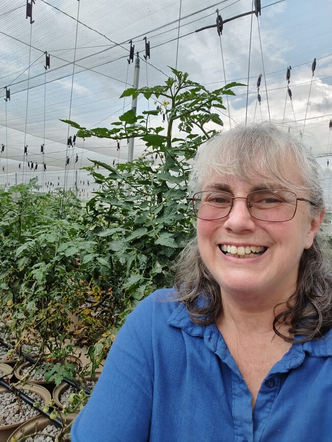 A woman taking a selfie inside her aquaponics farm.