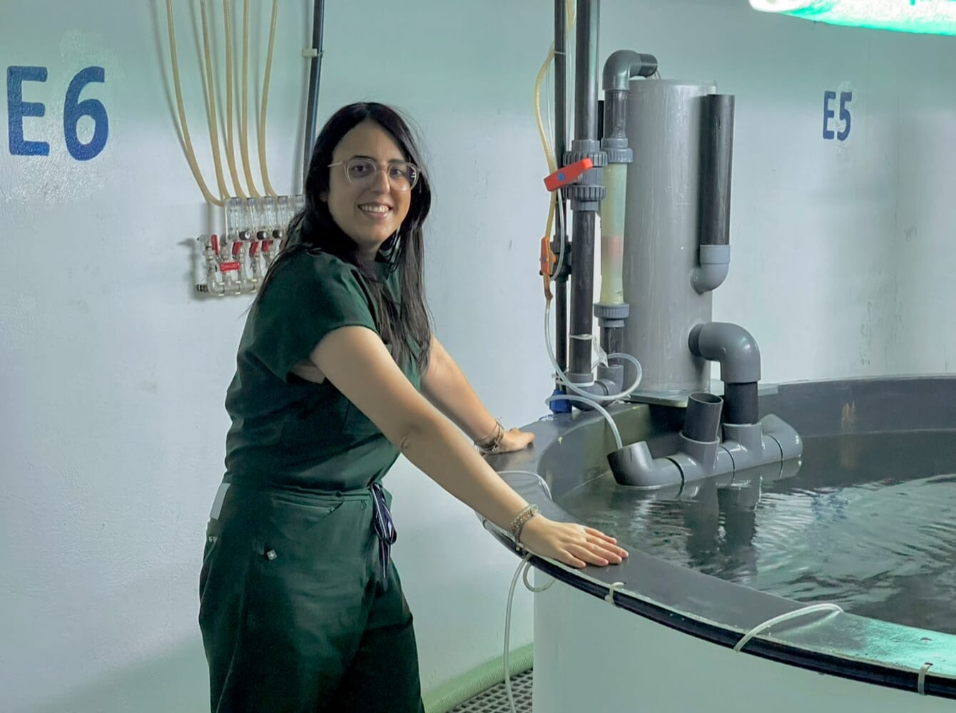 A woman leaning on a fish tank.