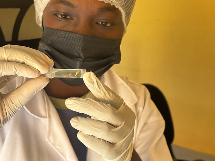 person in a lab coat holding a sample