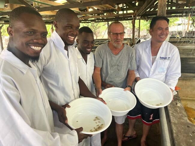 People holding bowls of crablets in a hatchery