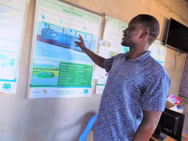 Man pointing to a poster on the wall