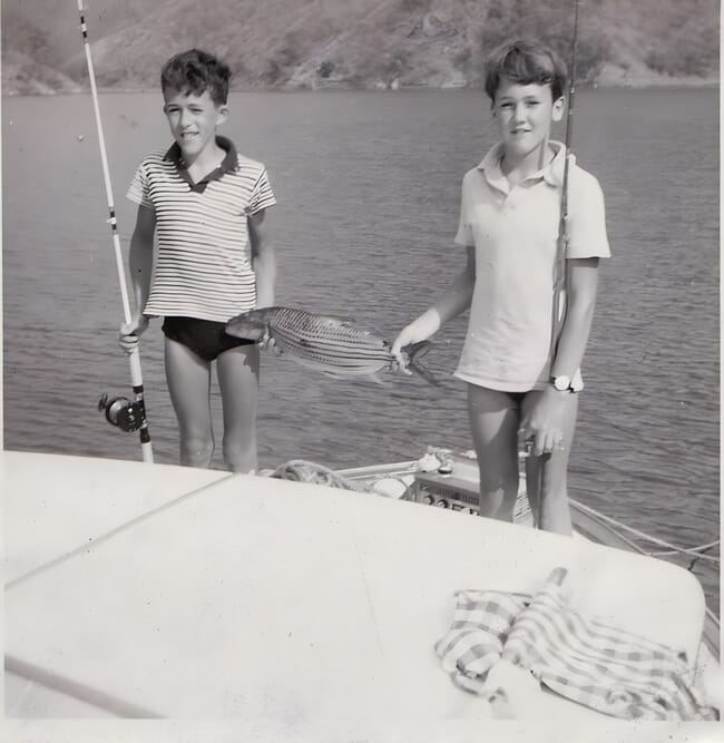 An old picture of two boys fishing.