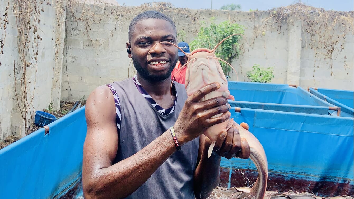 Hombre sonriente con un pez en la mano