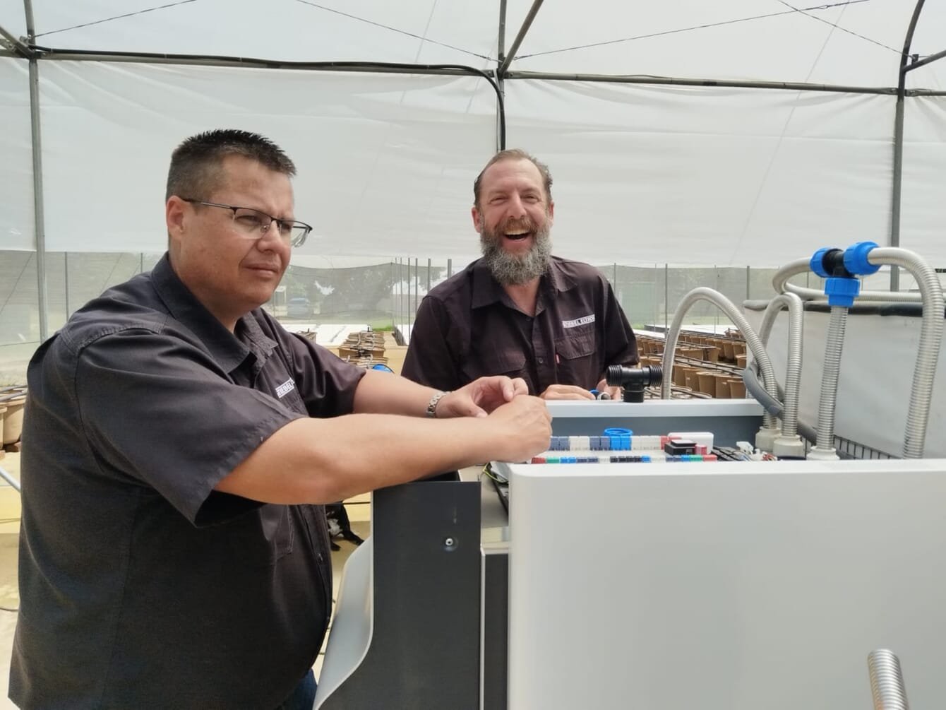 Two men standing inside an aquaponics farm in South Africa.