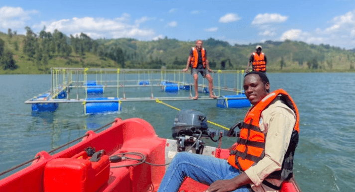 person sitting in a boat near an aquaculture pen