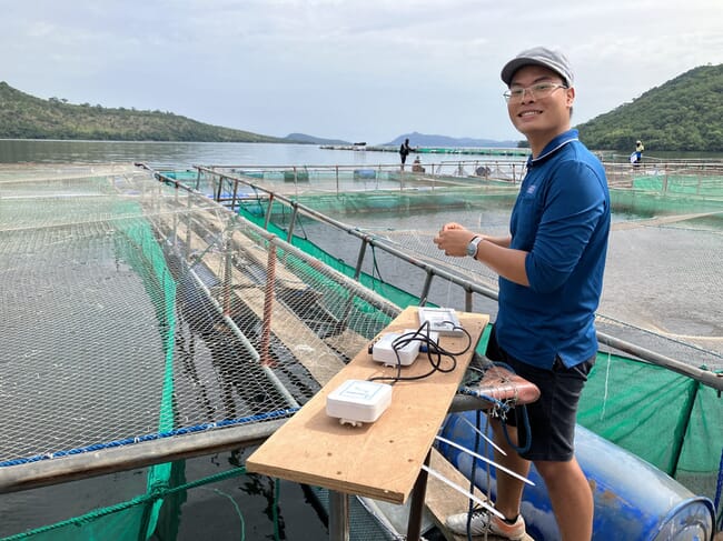 a man standing on a floating fish farm
