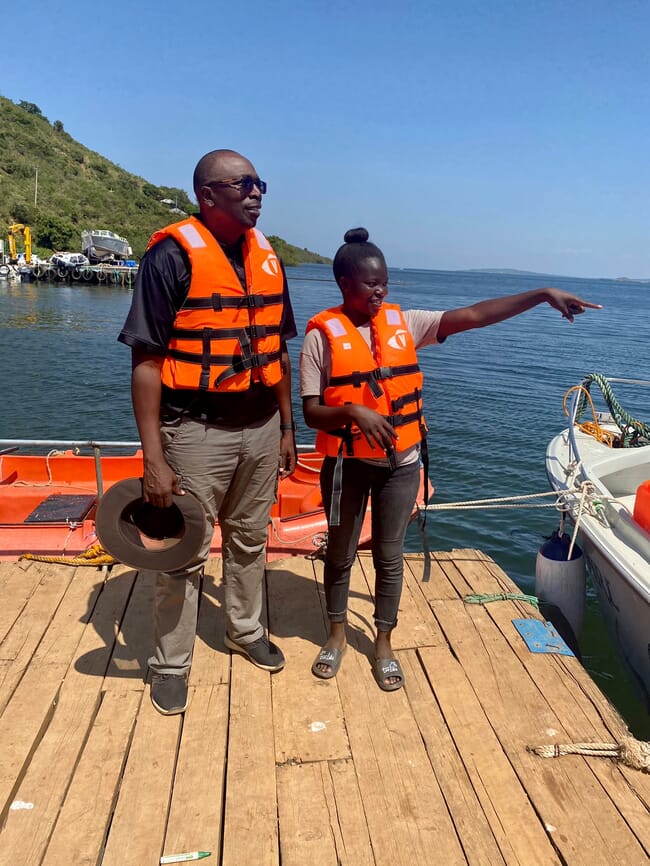 A man and a woman standing on a jetty looking out at open water