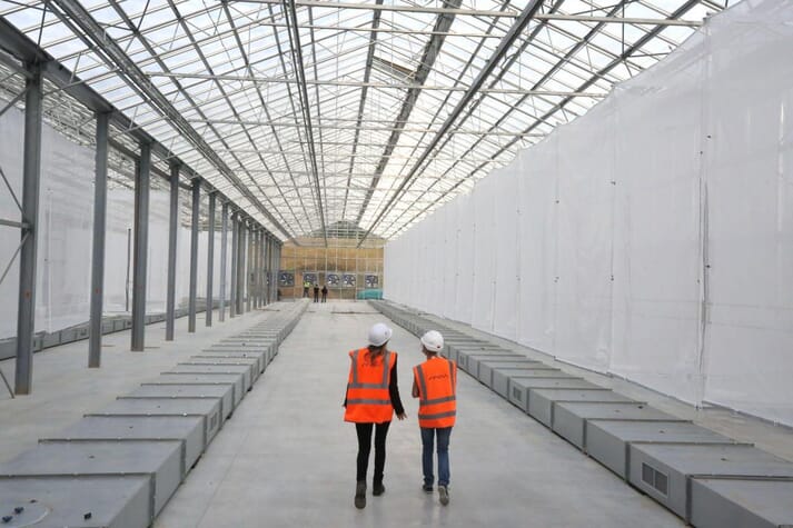 two people walking through a warehouse