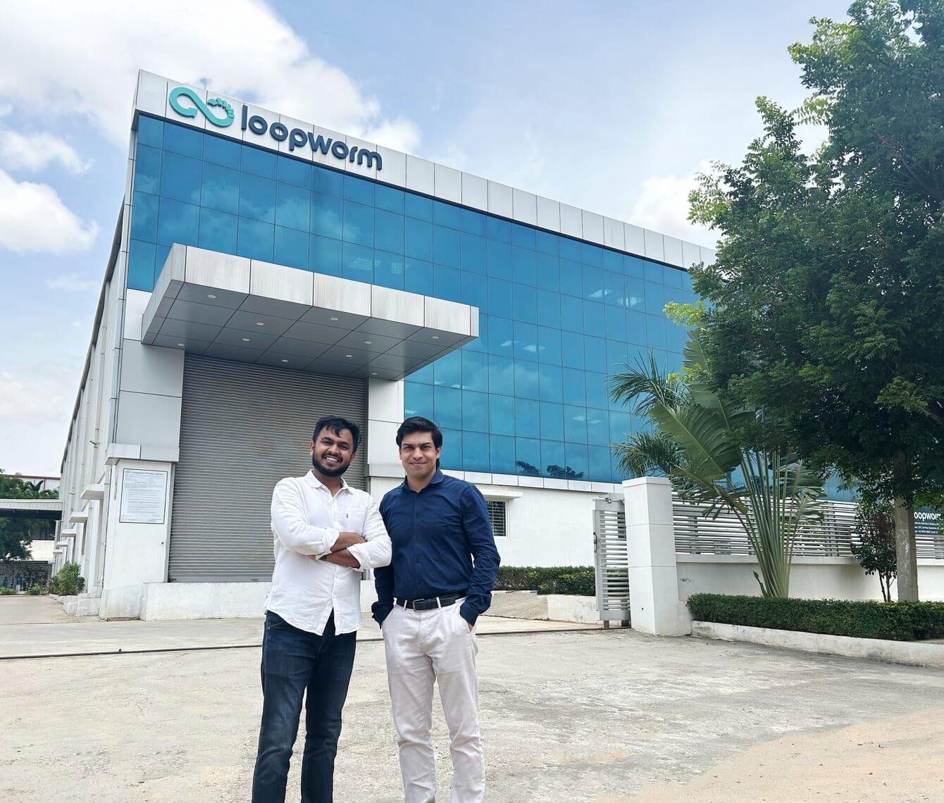 Two company co-founders standing infront of their company on a sunny day.